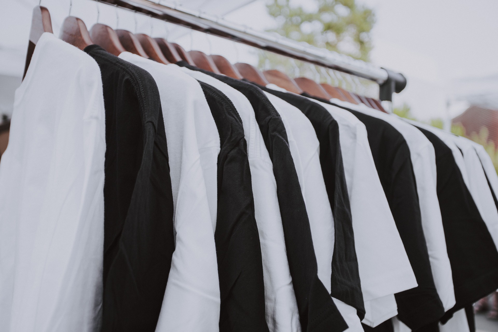 Collection of Black and White Color T shirt Hanging On Rack